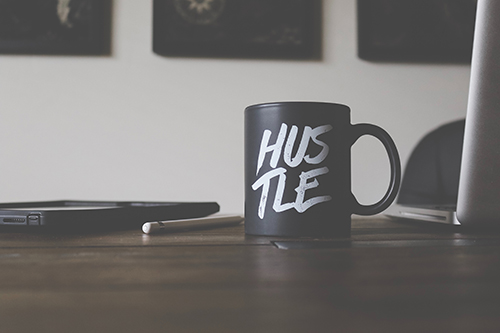 Coffee cup with word hustle